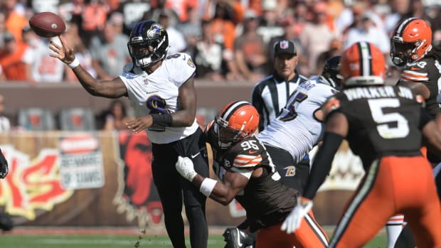 Oct 1, 2023; Cleveland, Ohio, USA; Baltimore Ravens quarterback Lamar Jackson (8) throws a pass as Cleveland Browns defensive end Myles Garrett (95) rushes during the second half at Cleveland Browns Stadium. Mandatory Credit: Ken Blaze-USA TODAY Sports